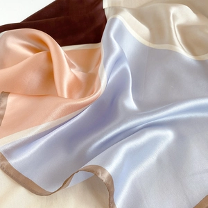 Detailed close-up of premium silk scarf featuring modern geometric color block design