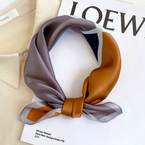Silk neck scarf with geometric color block patterns in brown and navy blue on a white magazine