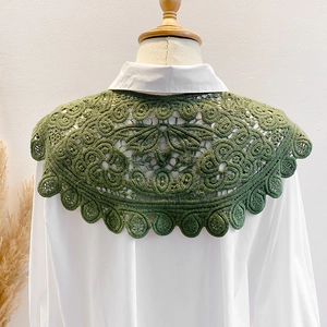 Detail of green lace embroidered hollow shawl with intricate floral crochet patterns