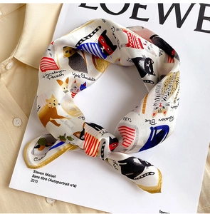 Detailed view of silk scarf with cartoon cat prints and hand-rolled golden edges