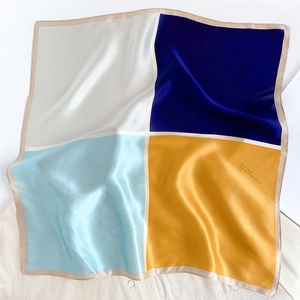 Detail of silk square scarf showing the four-color patchwork and smooth satin texture