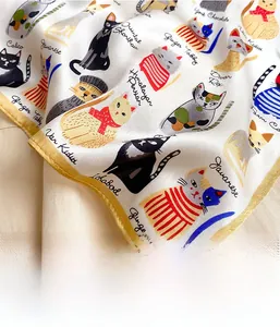 Detailed close-up of machine-rolled edges on a silk scarf with cat breed illustrations