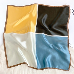 Detail of color-block silk scarf in yellow, black, beige, and light blue satin
