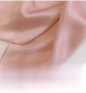 Close-up of pink silk scarf showing soft satin luster and delicate fabric texture