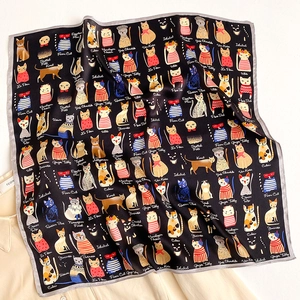 Detail of silk scarf showing cute cat illustrations and breeds on black fabric texture