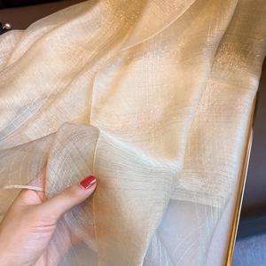 Detail of champagne gold silk blend scarf showing sheer metallic threads and texture