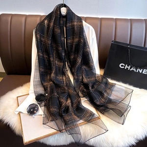 Close-up of lightweight silk blend scarf with metallic gold checkered patterns on black
