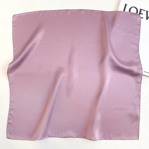 Detail of light purple silk square scarf with satin finish and smooth edges on white background