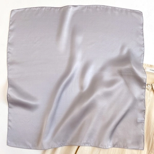 Close-up of silver-grey square silk scarf with elegant satin luster and neat edges