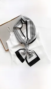 Detail of striped narrow scarf tied on silk top showing the 15x145cm size and texture