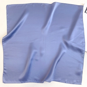 Detailed close-up of smooth blue-purple silk scarf with elegant satin sheen and neat edges