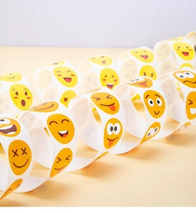 Macro view of a continuous roll of yellow emoji smiley face reward stickers for children