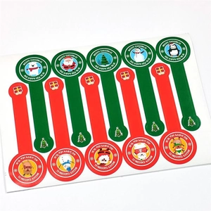 Macro detail of cartoon Christmas stickers featuring Santa, reindeer, and festive greetings