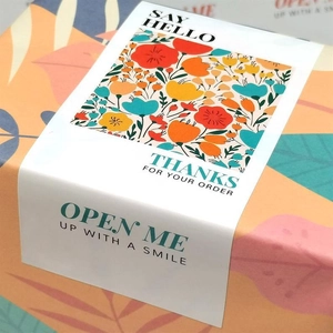 Close-up of rectangular stickers with orange floral patterns and thank you message
