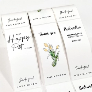 Macro shot of three minimalist white rectangular sticker rolls with tulip art and text