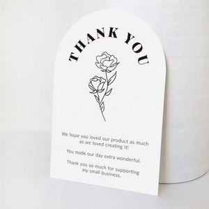 Macro shot of arched pink thank you gift card with floral rose design and text