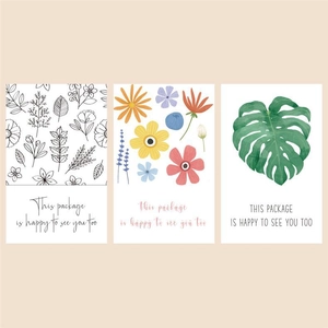 Macro shot of rectangular botanical packaging labels with green leaf and flower designs