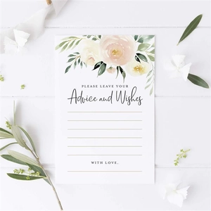 Detailed view of white floral wedding advice and wishes card on wooden surface