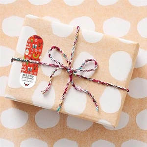 Detailed view of festive long Christmas stickers used for sealing white dotted gift boxes