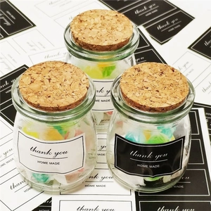 Glass jars with cork lids and handmade thank you stickers for packaging and decor