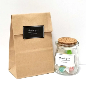 Brown kraft paper bag and glass jar with Thank You Homemade stickers on white background