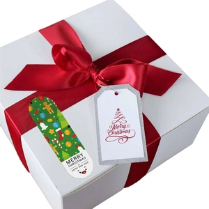 Christmas gift stickers with festive gingerbread and red tree designs on white gift box
