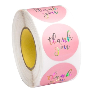 Macro detail of holographic thank you stickers on a roll with pink circular labels
