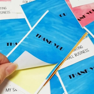 Macro view of blue ocean texture Thank You stickers being peeled from backing paper