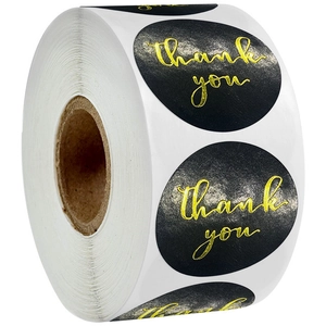 Macro view of gold foil Thank You text on black oval sealing stickers in a roll format