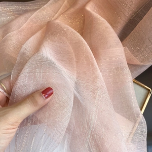Macro shot showing pink silk blend scarf texture with shimmering gold metallic threads