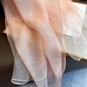 Macro detail of pink semi-transparent silk blend scarf with subtle metallic glitter textures