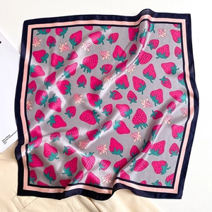 Detail of silk square scarf featuring strawberry print and contrast borders