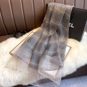 Detailed view of dark grey silk blend scarf with thin grid pattern and soft texture