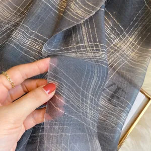 Detail shot of grey silk blend scarf with metallic lurex threads and sheer mesh texture