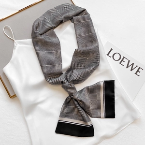 Elegant black and white houndstooth skinny silk scarf tied on a white satin camisole top