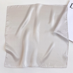 Detail of silver silk square scarf showing soft satin texture and smooth edges