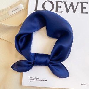 Navy blue mulberry silk square scarf styled on a beige shirt with high-gloss satin texture