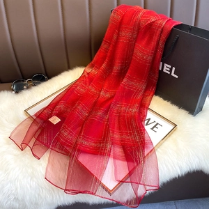 Detailed close-up of red silk blend scarf with golden shimmer metallic thread grid pattern