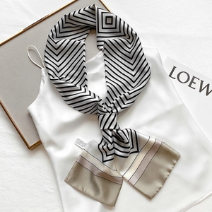 Detail of silk scarf with geometric patterns and champagne accents on a white fabric
