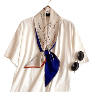 Floral silk neck scarf with chain pattern styled on a white shirt with sunglasses