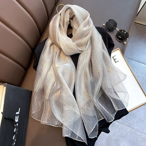Detail of light gray silk blend scarf with metallic gold stripes on black shirt