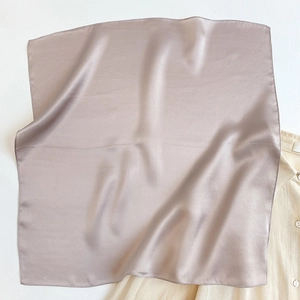 Detailed view of dusty purple silk scarf texture with smooth satin sheen and hemmed edges