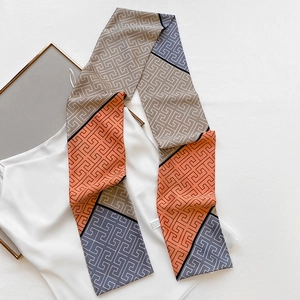 Detail of multi-color geometric pattern silk scarf with sleek satin texture and wash label