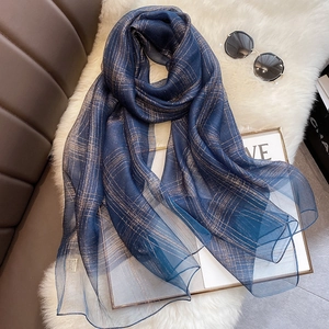 Detail of dark blue silk blend scarf with golden metallic thread plaid pattern