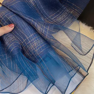 Detailed macro shot of dark blue silk blend scarf with metallic gold checkered weave
