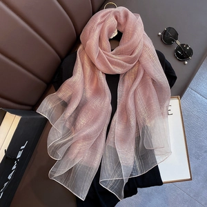 Detail of a pink silk blend scarf featuring gold metallic thread and thin texture