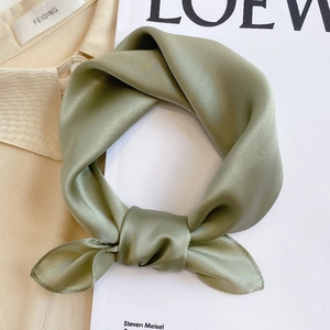 Detail of elegant olive green silk scarf with smooth satin texture in a knotted style