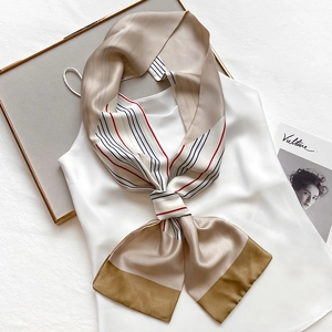 Elegant striped silk skinny scarf with red and blue accents on a white camisole