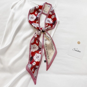 Eleganter rot-weißer Seidenschal mit Blumenmuster auf einem weißen Satinkleid