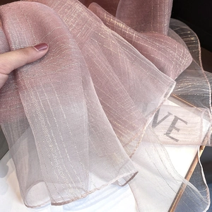Macro shot of dusty pink sheer scarf featuring fine gold metallic stripes and light texture